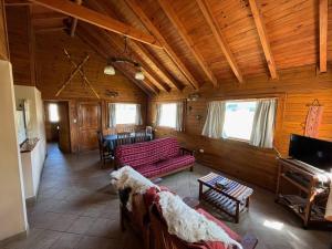a living room with couches and a piano in a cabin at Cabañas Las Cascadas in Caviahue