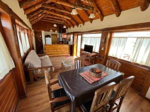 a dining room with a table and chairs in a cabin at Cabañas Las Cascadas in Caviahue