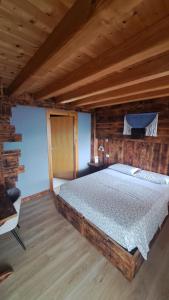 a bedroom with a bed in a log cabin at B&B Val Maschi in Lamon