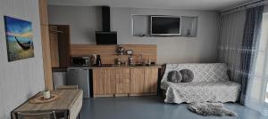 a living room with a chair and a kitchen at Idille Studio with Patio & Free Parking in Ventspils