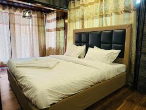 a bedroom with a large bed with white sheets at Id villa in Tangmarg