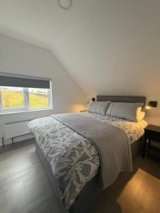 a bedroom with a large bed with a large window at An Camus Ballyliffin in Ballyliffin
