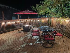 a patio with a table and chairs and an umbrella at Le Saint Louis de lotbinière in Lotbinière