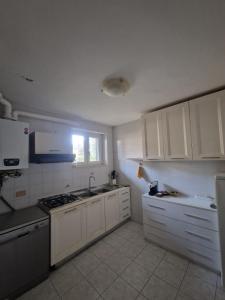 a kitchen with white cabinets and a sink and a window at Villa Aurora in Tirrenia