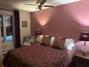 a bedroom with a bed and a chair and a ceiling fan at Le Saint Louis de lotbinière in Lotbinière +1 photo