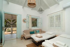 a living room with two beds and a couch at Varka Bungalows in Methoni