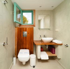 a bathroom with a white toilet and a sink at Varka Bungalows in Methoni