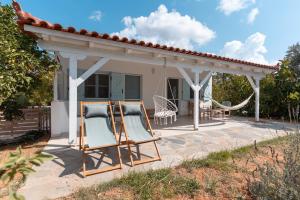 a patio with two chairs and a gazebo at Varka Bungalows in Methoni