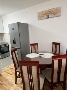 a kitchen with a table and chairs and a refrigerator at Pantelej gates in Niš