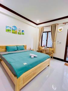 a bedroom with a large bed with blue sheets at SUN Homestay Vĩnh Hy in Vĩnh Hy +26 photos