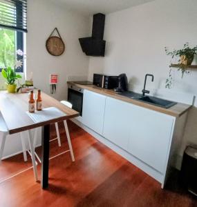 a kitchen with a table and a sink and a counter at Au Coin du Bois in Theux