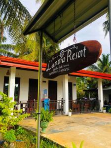 a sign in front of a restaurant with a surfboard at Lumora Resort in Nochchiyagama
