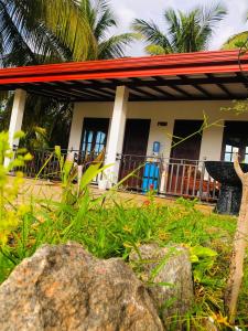 a house with a red roof and some plants at Lumora Resort in Nochchiyagama