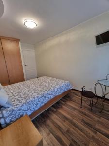 a small bedroom with a bed and a table at Airida Forest Apartment in Druskininkai