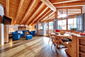a living room with a table and blue chairs at Föhrenhof Apartments in Farchant