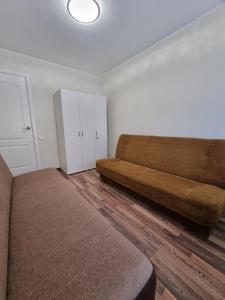 a living room with a couch and a cabinet at Airida Forest Apartment in Druskininkai