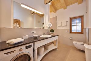 a bathroom with a sink and a washing machine at Föhrenhof Apartments in Farchant +79 photos