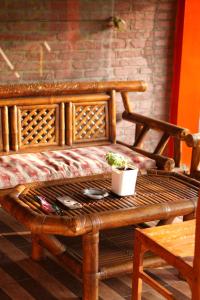 a wooden bench with a table with a plant on it at Swindo Homestay 77, Room 1 in Berastagi +27 photos