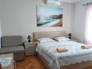 a bedroom with a bed and a picture of a beach at lopar 239 in Lopar