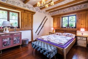 a bedroom with a bed and a table and windows at Ranczo Pod Strzechą in Stara Kamienica
