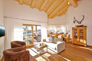 a living room with a white couch and chairs at Föhrenhof Apartments in Farchant