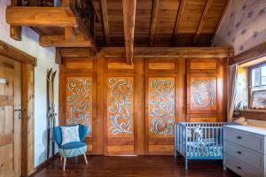 a room with wooden doors and blue chairs at Ranczo Pod Strzechą in Stara Kamienica