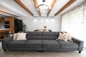 a gray couch in a living room with a chandelier at Hal Wardija - Gozo Hideaways in Qala +18 photos