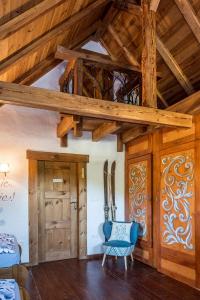 a living room with wooden ceilings and a blue chair at Ranczo Pod Strzechą in Stara Kamienica