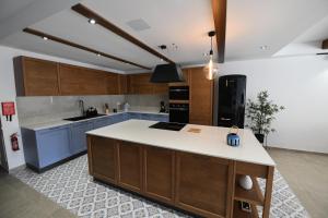 a kitchen with wooden cabinets and a white counter top at Hal Wardija - Gozo Hideaways in Qala