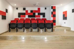 a group of red chairs sitting in a room at Seafront 2B Apartment with Pool, Spa & Gym Torrox in Torrox +46 photos