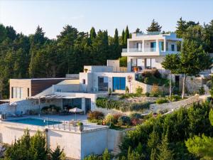 a house with a garden and a swimming pool at Dreamcatcher Villas by PaxosRetreats in Velianitátika