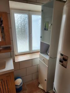 a kitchen with a refrigerator and a window at La maison bleue in Velet +16 photos