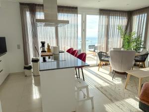 a living room with a glass table and chairs at Seafront 2B Apartment with Pool, Spa & Gym Torrox in Torrox