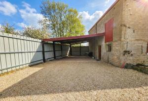 a large brick building with a garage and a fence at La maison bleue in Velet