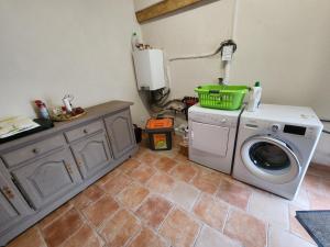 a laundry room with a washing machine and a washer at La maison bleue in Velet