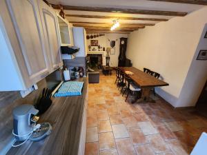 a kitchen and dining room with a table and chairs at La maison bleue in Velet