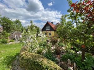 a garden in front of a yellow house at Ferienwohnung Anna in Benneckenstein
