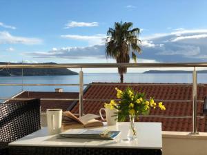 a table with a vase of flowers on a balcony at Boka Residence 7 in Herceg-Novi