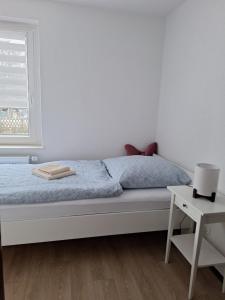 a bedroom with a bed and a window and a table at Stadt Land Ferienhaus in Falkensee