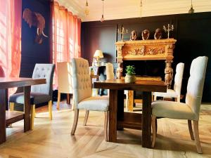 a dining room with a table and chairs and a fireplace at Château des Bourdons Charme, Spa & Nature in Varennes Vauzelles