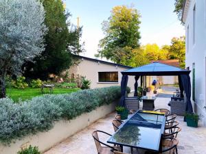 a patio with a table and chairs and an umbrella at Château des Bourdons Charme, Spa & Nature in Varennes Vauzelles