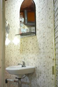 a bathroom with a sink and a mirror at Swindo Homestay 77, Room 11 in Berastagi