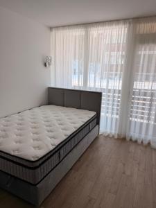 a bed in a room with a large window at Smilties apartamentai in Juodkrantė