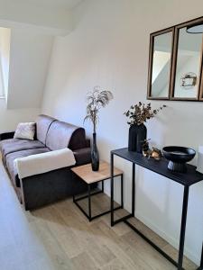 a living room with a couch and a table at Chez Vincent - Centre Historique de Colmar avec parking inclus in Colmar