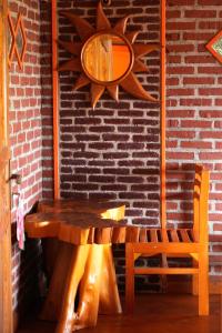 a wooden table and a chair next to a brick wall at Swindo Homestay 77, Room 11 in Berastagi