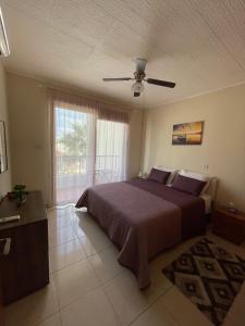 a bedroom with a bed and a ceiling fan at Seascape apartment in Larnaca