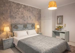 a bedroom with a bed and two lamps and a wall at Art Suites Mesologgi in Missolonghi