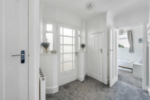 a white room with a door and a bedroom at Ocean View in Worthing, 5 bedrooms for 10, 3 Bathrooms, Hot Tub, Parking for 6, Seaview in Sompting +59 photos