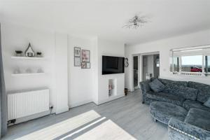 a living room with a couch and a tv at Ocean View in Worthing, 5 bedrooms for 10, 3 Bathrooms, Hot Tub, Parking for 6, Seaview in Sompting