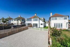 a large house with a fence and a driveway at Ocean View in Worthing, 5 bedrooms for 10, 3 Bathrooms, Hot Tub, Parking for 6, Seaview in Sompting